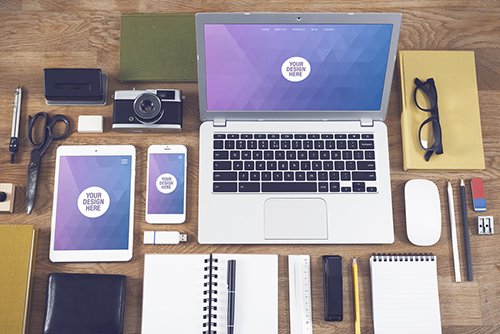 Laptop, Tablet, and Smartphone with Many Objects on a Wooden Desk Mockup